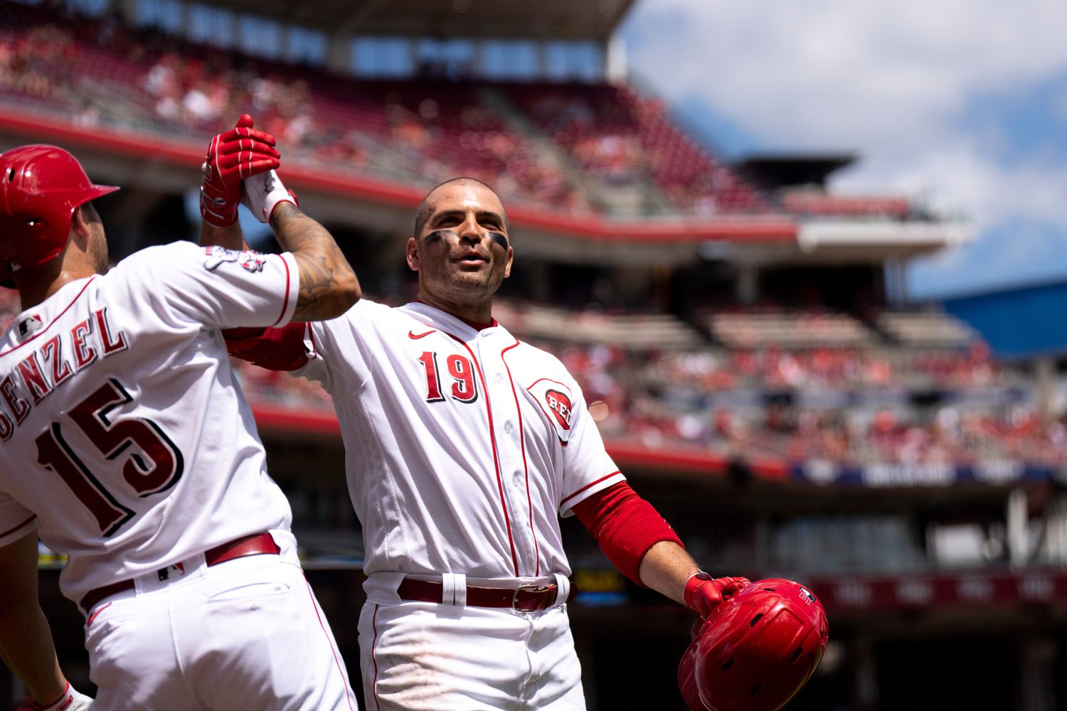 Cincinnati Reds first baseman Joey Votto (19) grabs Cincinnati Reds third baseman Nick Senzel (15) after hitting a solo home run in the second inning of the MLB baseball game between Cincinnati Reds and Washington Nationals at Great American Ball Park in Cincinnati on Sunday, Aug. 6, 2023.